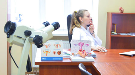 в гинекологическом кабинете женщина врач гинеколог на заднем плане проверяет результаты колькоскопии